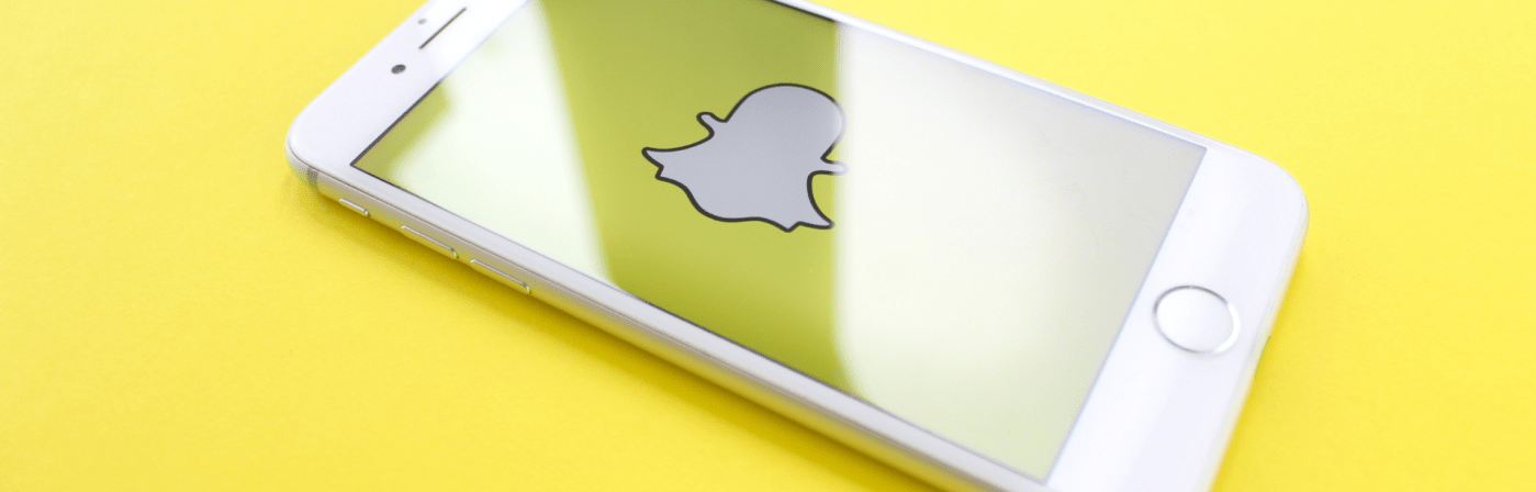 iPhone with snap chat icon on it with yellow background