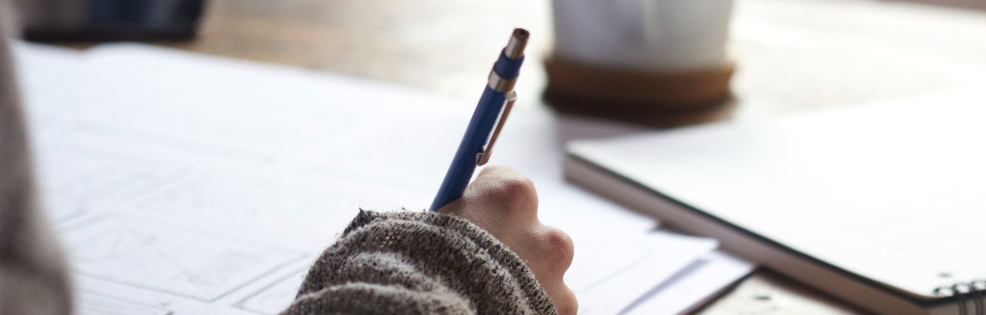 hand holding pen writing on paper